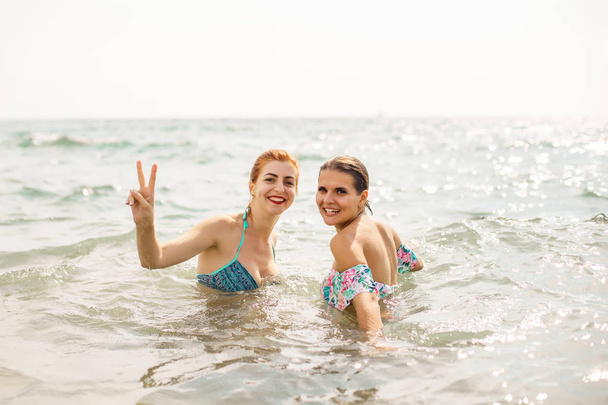 Two happy young girls bathing in sea - Fotografie, Obrázek