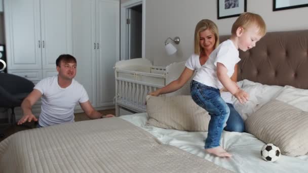 Familia feliz jugando a las almohadas lucha en la cama en casa
 - Imágenes, Vídeo