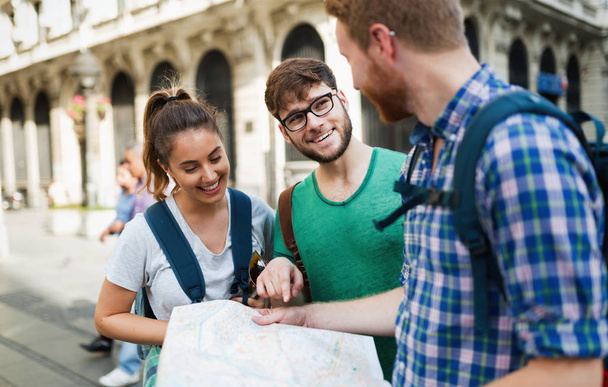 Νεαρών τουριστών ευτυχισμένη κρατώντας Χάρτης Αξιοθέατα στην πόλη - Φωτογραφία, εικόνα