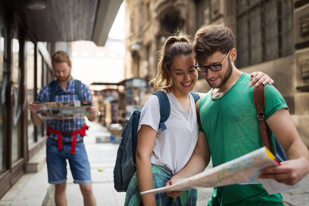 Jeunes touristes heureux tenant carte touristique dans la ville
 - Photo, image