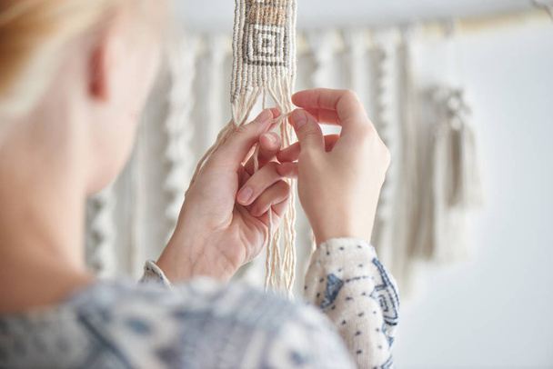 needlewoman making knots on threads, weave concept  - Foto, Imagen