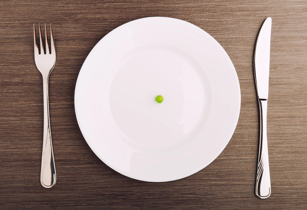Diéta fogalma. egy üres fehér tányérra egy borsó - Fotó, kép