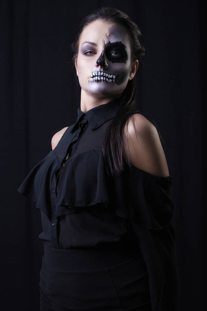 joven con aterrador maquillaje posando sobre fondo negro
  - Foto, imagen