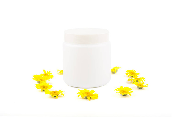 White mocap for cream, balm, mask and small yellow daisies on a white background. Isolate, close-up, front view - Photo, Image