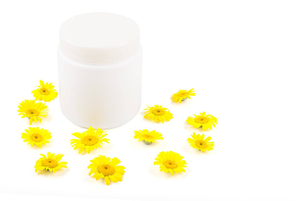 White mocap for cream, balm, mask and small yellow daisies on a white background. Isolate, close-up, front view - Fotó, kép