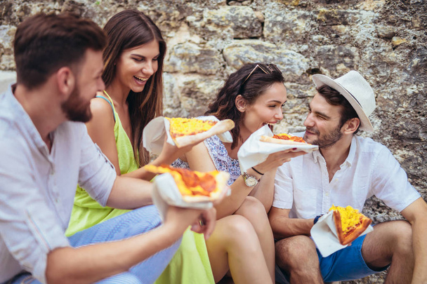 Счастливые люди едят фаст-фуд в городе во время путешествия
 - Фото, изображение