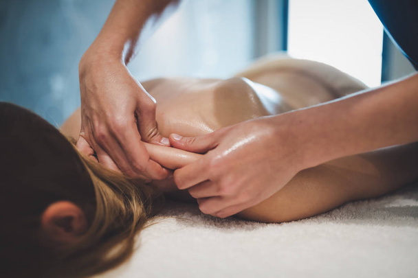 Professional masseur therapist massaging patient at wellness spa - Zdjęcie, obraz
