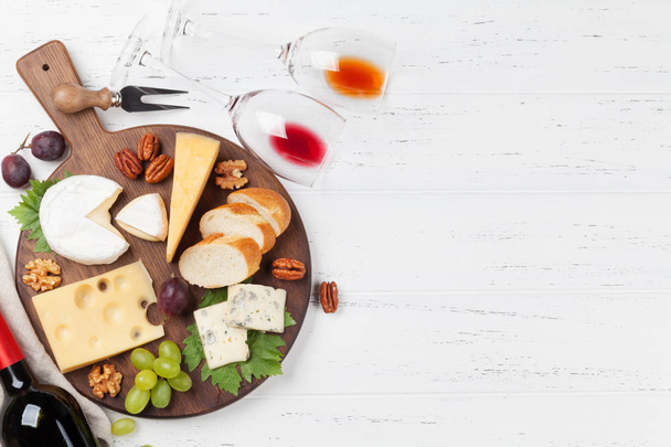 Wijn, kaas, druif, brood en noten op witte houten achtergrond. Bovenaanzicht met ruimte voor uw tekst - Foto, afbeelding