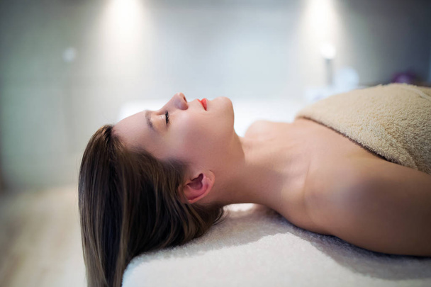 schöne Frau entspannt sich auf Massagebett im Kosmetiksalon - Foto, Bild
