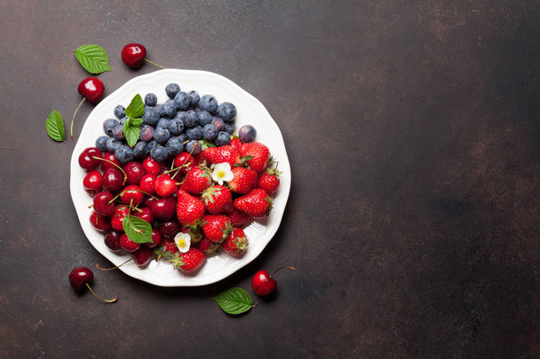 Fresh summer berries. Cherries, blueberries and strawberries in bowl. Top view with space for your text - Photo, Image