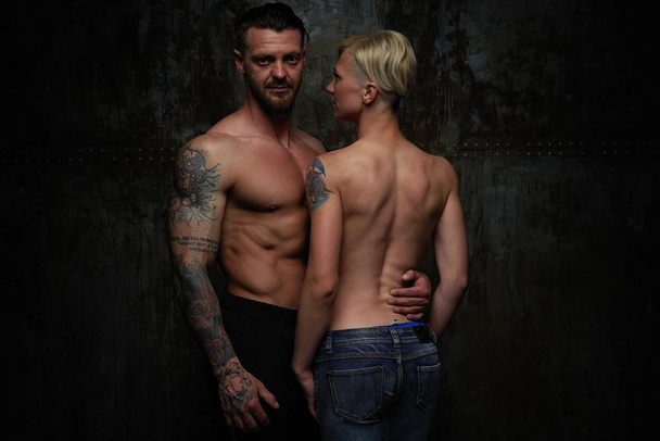Beautiful modern couple shirtless posing in studio on grey background - Foto, Imagem
