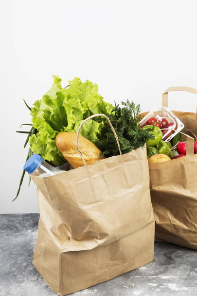 Various healthy food in paper bag on gray background - Foto, imagen