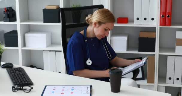 Arzt in blauer Uniform macht Notizen auf Papier - Filmmaterial, Video