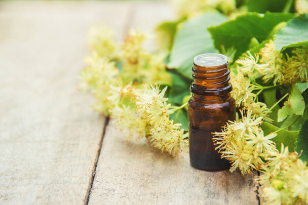 linden extract and flowers in a small bottle. Selective focus. - Photo, Image