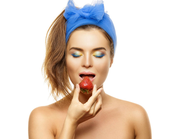 Beautiful woman with colorful makeup and strawberry on white background - Foto, Imagem