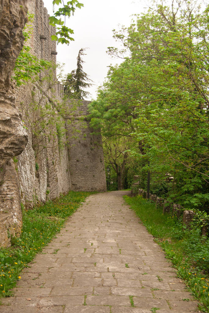 Pohled na pěší ulice s dlážděnými jít na vrcholu kopce San Marino u obvodové zdi - Fotografie, Obrázek