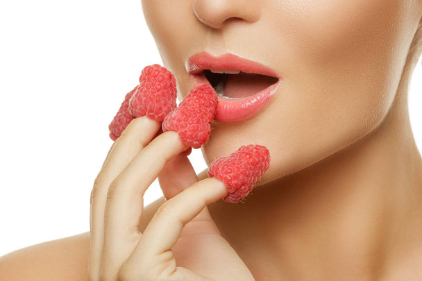 Close up view of female lips and raspberries - Фото, зображення