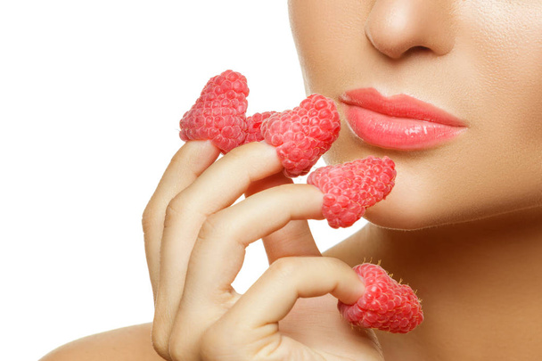 Close-up van vrouwelijke lippen en frambozen - Foto, afbeelding