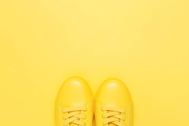 Pair of yellow shoes on yellow background. - Photo, Image