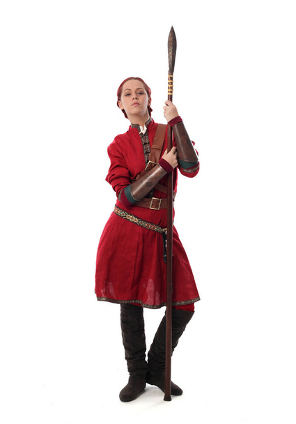 Ολόσωμο πορτρέτο του κόκκινα μαλλιά κορίτσι φορώντας φαντασίας μεσαιωνικού κοστούμι, όρθια στάση στο ιστορικό στούντιο. - Φωτογραφία, εικόνα