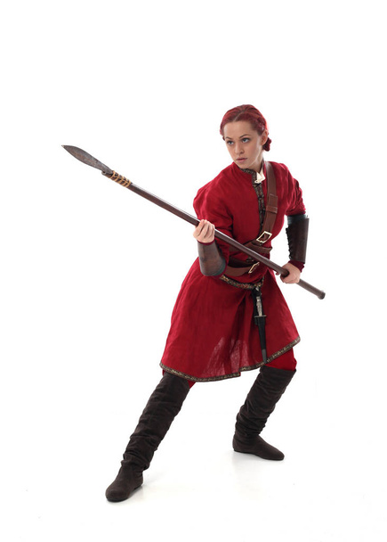 full length portrait of red haired girl wearing fantasy medieval costume, standing pose on studio background. - Фото, изображение