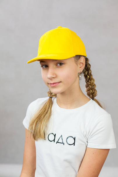 cute girl with pigtails in a cap - Фото, зображення