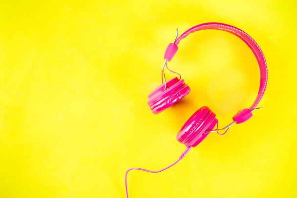 Bright pink headphones  on yellow background - Photo, Image