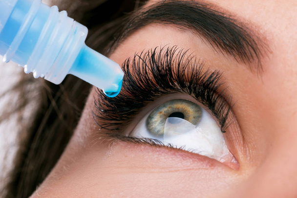 Close up view of woman using eye drops - Foto, afbeelding