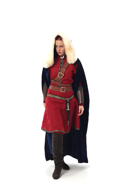 Ολόσωμο πορτρέτο του κόκκινα μαλλιά κορίτσι φορώντας φαντασίας μεσαιωνικού κοστούμι, όρθια στάση στο ιστορικό στούντιο. - Φωτογραφία, εικόνα