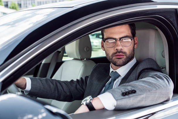 portrait of businessman in eyeglasses driving car - Foto, imagen