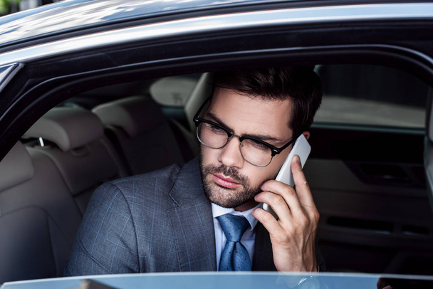 ritratto di un uomo d'affari che parla su smartphone sul sedile posteriore in auto
 - Foto, immagini