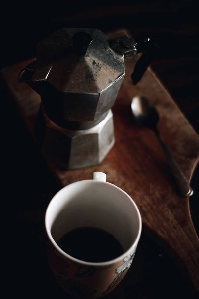 スプーンで木製のテーブルにコーヒーとアルミニウムの萌香エスプレッソ メーカーの白いカップ - 写真・画像