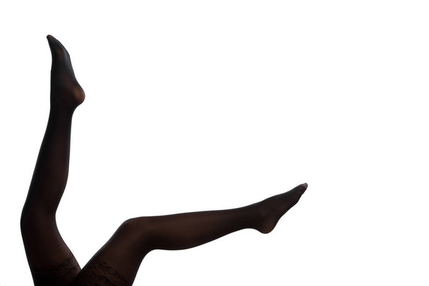 Струнка жінка ноги в чорних панчохах махає в білому
 - Фото, зображення
