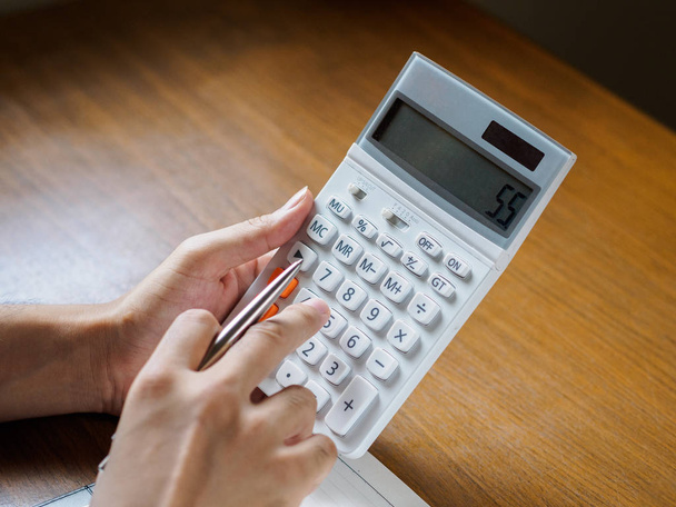 Közel álló férfi kezében számológéppel fából készült asztal. üzleti, oktatási koncepció. - Fotó, kép