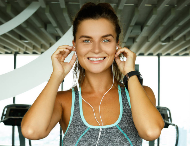 Sporty woman listening music during workout in gym - Фото, зображення