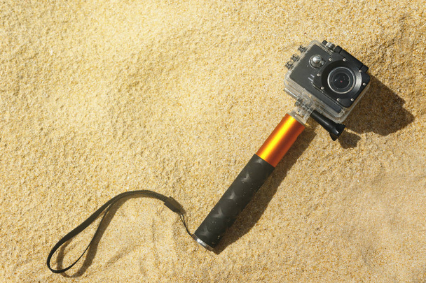 Macchina fotografica d'azione in custodia impermeabile con monopiede sulla spiaggia
 - Foto, immagini