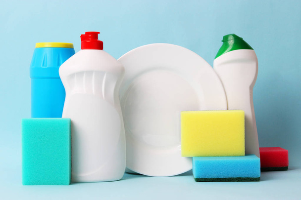 líquido lavavajillas, esponjas, plato sobre un fondo de color. tareas domésticas, lavar los platos
 - Foto, Imagen