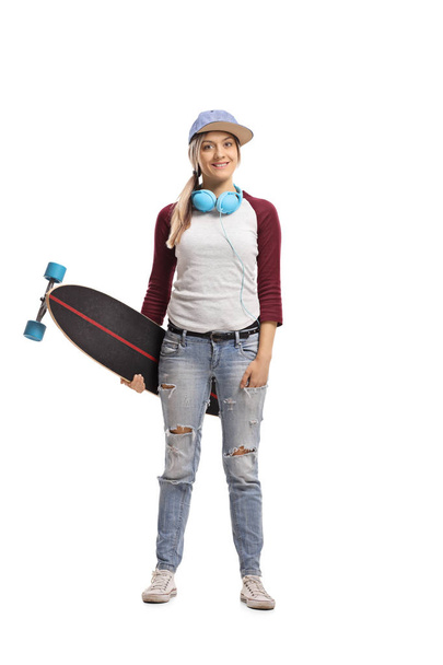 Full length portrait of a skater girl with a longboard isolated on white background - Zdjęcie, obraz