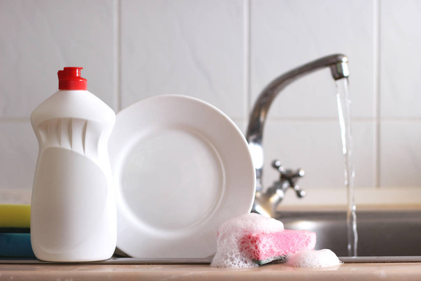 Detergentes e esponjas no fundo fora lavado da pia da cozinha
. - Foto, Imagem