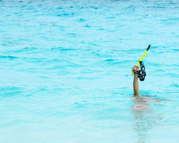 Male hand holding mask for snorkeling above water - Φωτογραφία, εικόνα