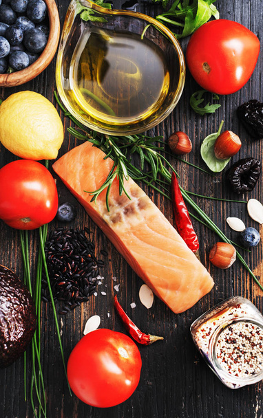 Selective of ingredients with fish and organic vegetables, cereals rich of amino acids,  oligominerals  for healthy seasonal cooking on black wooden background, top view, place for text. - Valokuva, kuva