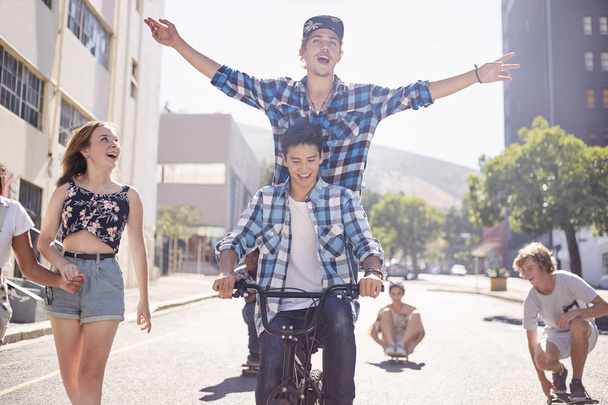 Εφηβική τους φίλους ιππασία ποδήλατο Bmx και Σκέιτμπορντ στην ηλιόλουστη αστική οδό - Φωτογραφία, εικόνα