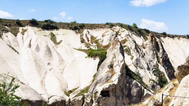Travel to Turkey - slope of valley with rock-cut ancient monastic settlement near Goreme town in Cappadocia in spring - Photo, Image