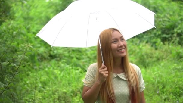 Vrouw lopen hand met witte paraplu onder regen  - Video
