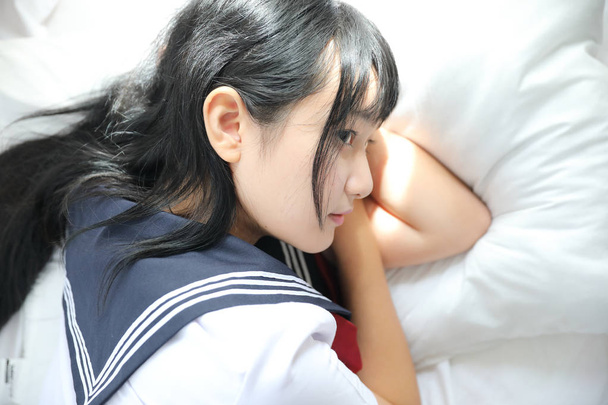 Portrait japanese school sleeping in white tone bed room - Foto, Imagem