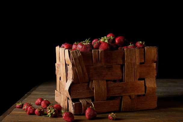ripe strawberries in rustic box on wooden surface and on black - Фото, зображення