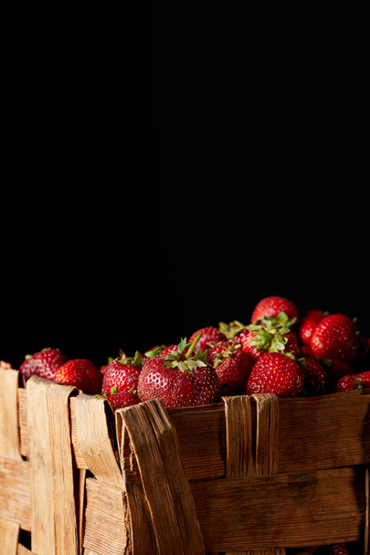 fresh red strawberries in rustic box isolated on black - Фото, изображение