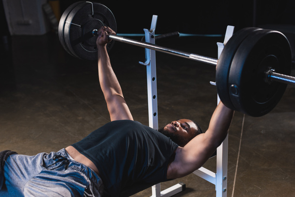 musculoso afroamericano deportista levantando barra en el gimnasio
  - Foto, imagen