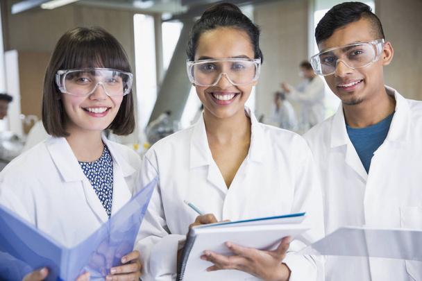 Porträt lächelnde College-Studenten in naturwissenschaftlichen Laborkitteln - Foto, Bild