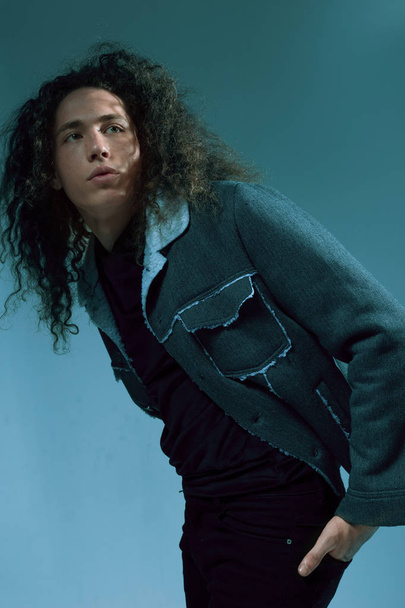 Portraits of a guy with an attractive appearance, curly hair and stylish clothes - Foto, afbeelding